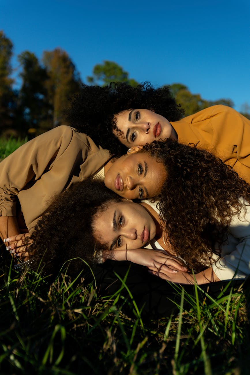 three women posing outdoors on a sunny day