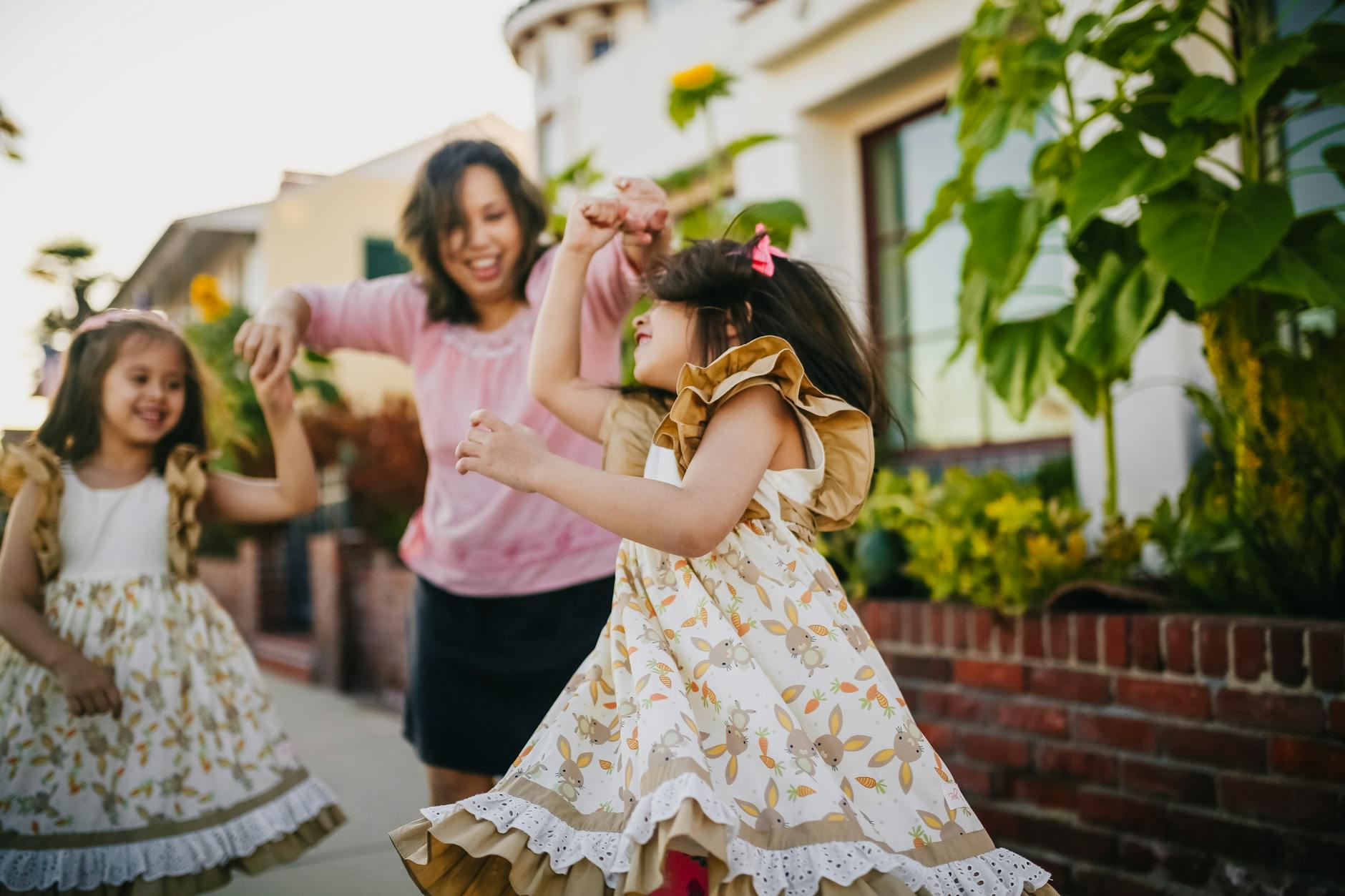mother dancing with her daughters on the street